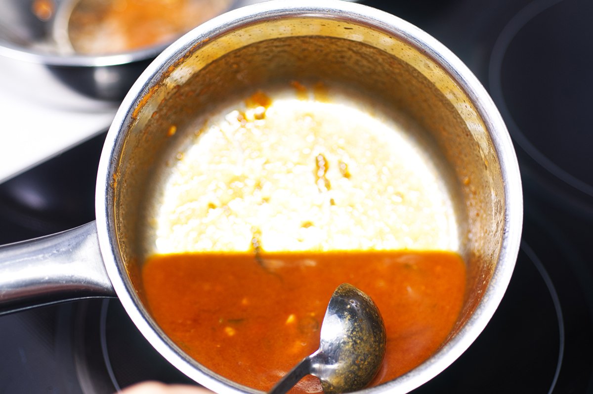 reducing sriracha honey wings sauce until it coats back of spoon