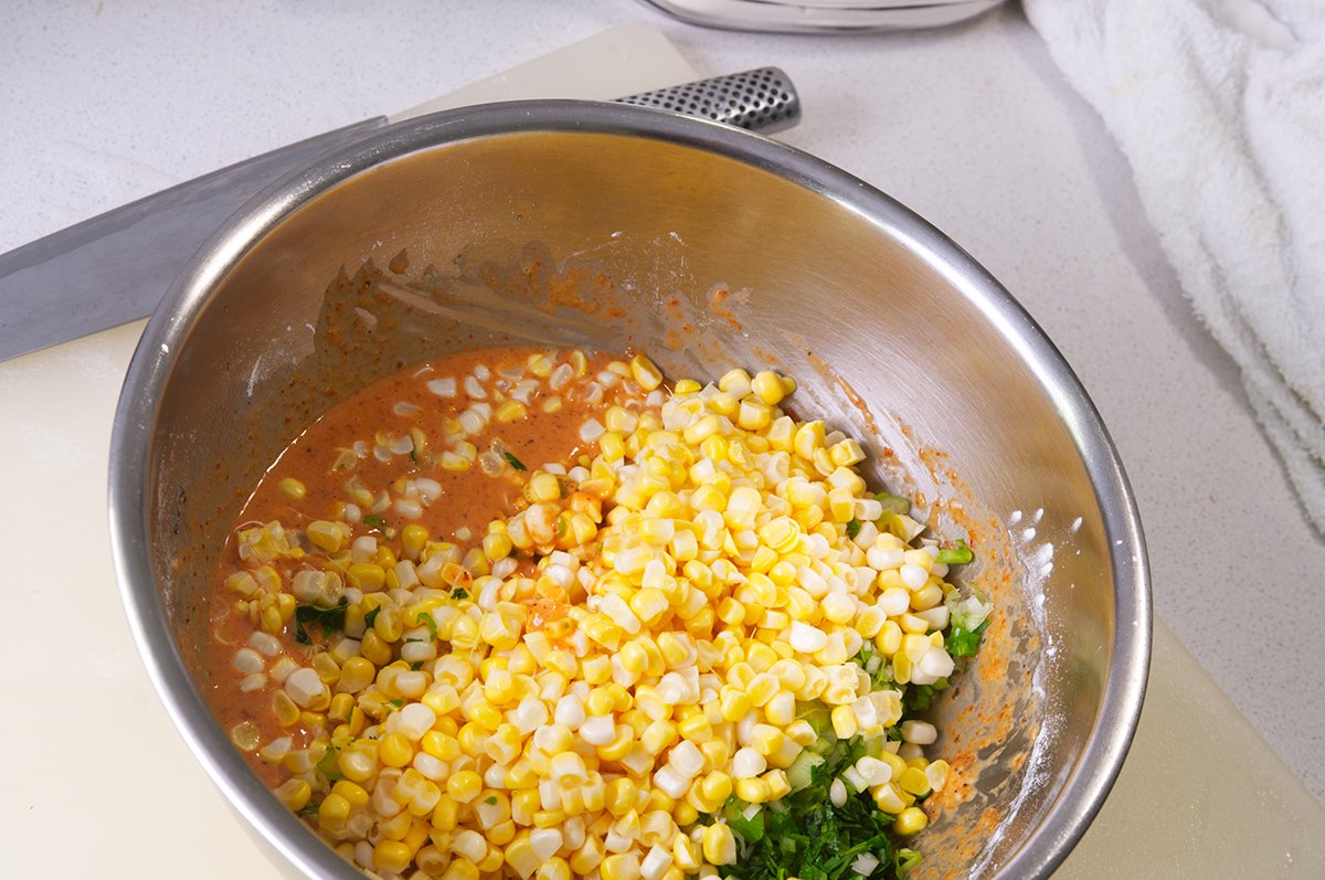adding the corn and cilantro to the batter