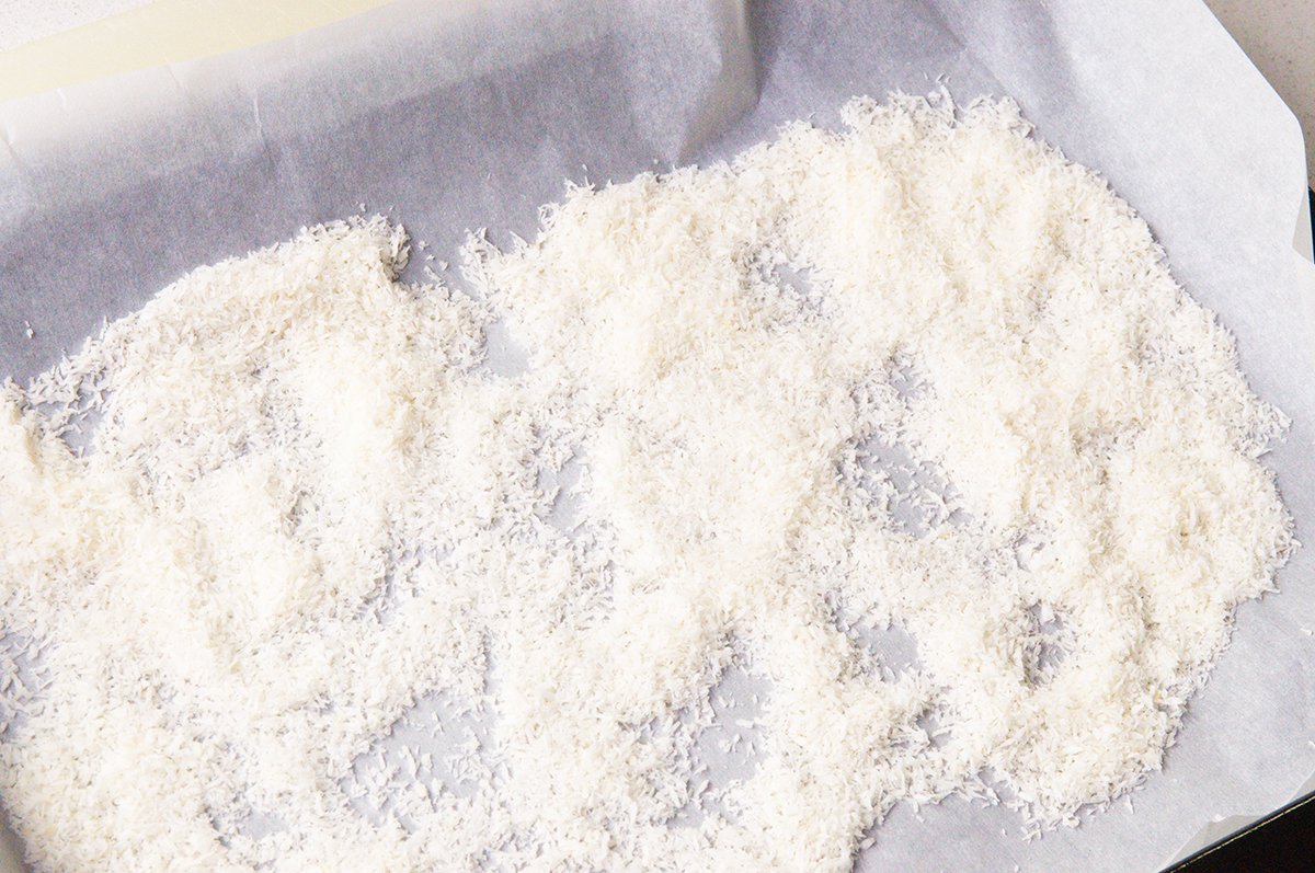 spreading coconut on baking pan for palitaw