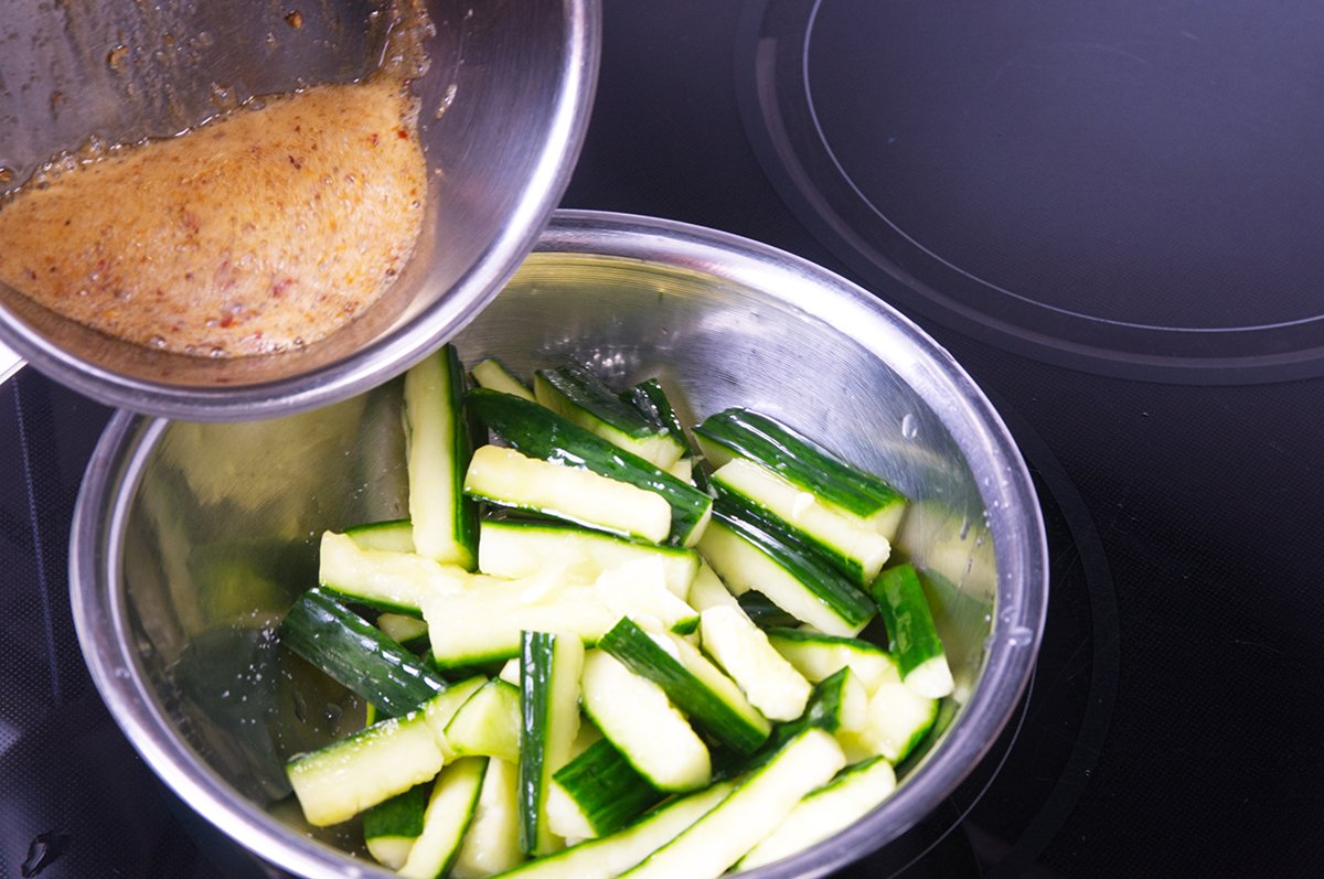 pouring the hot oil on the cucumbers