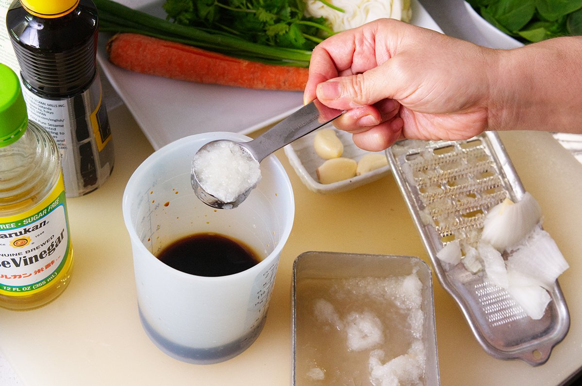 adding grated onion to noodle salad dressing