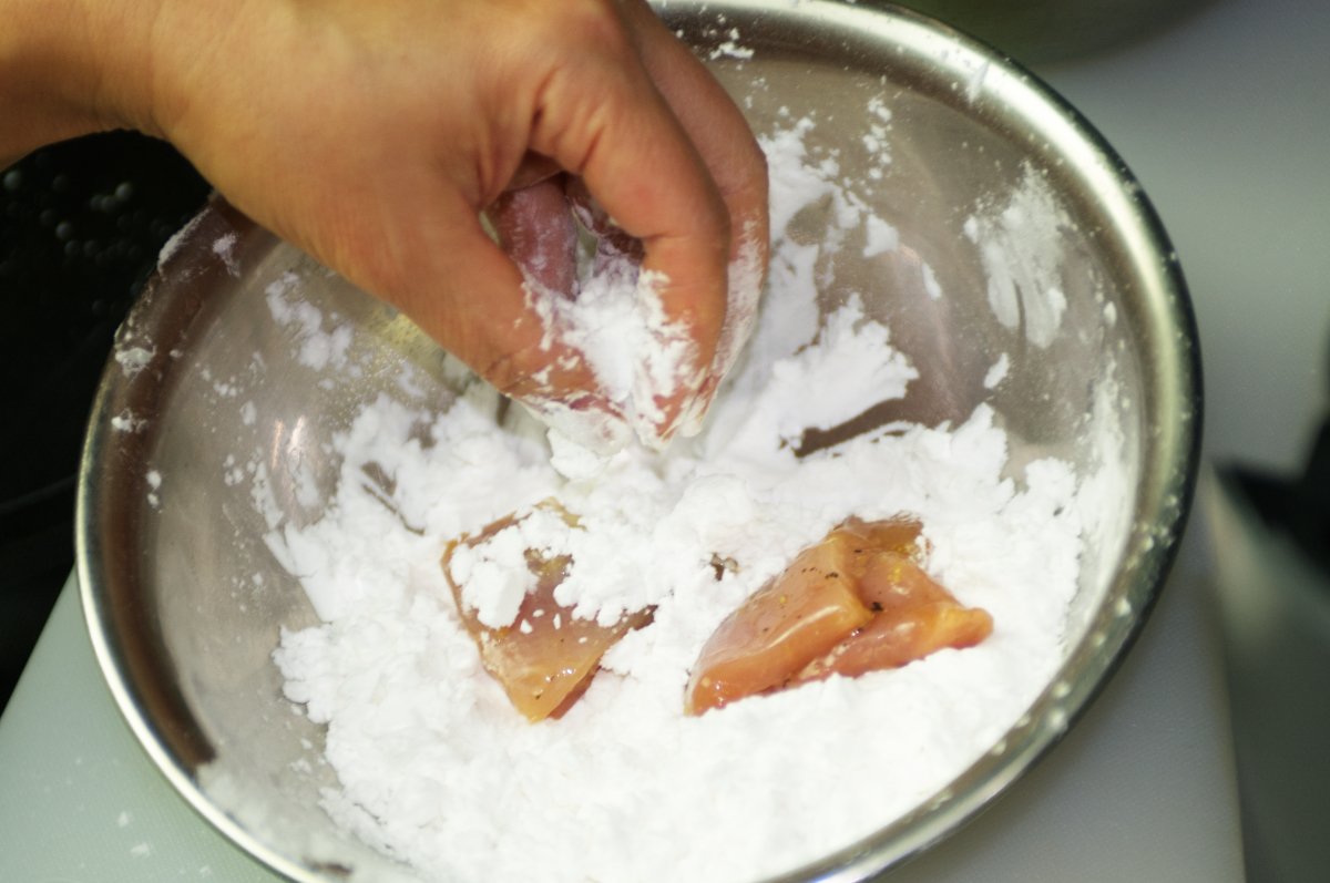 dredging pieces in potato starch for Japanese fried chicken