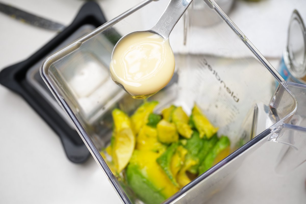 adding condensed milk to the blender