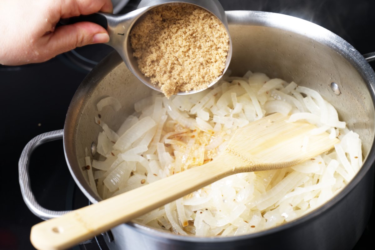 adding brown sugar to onions