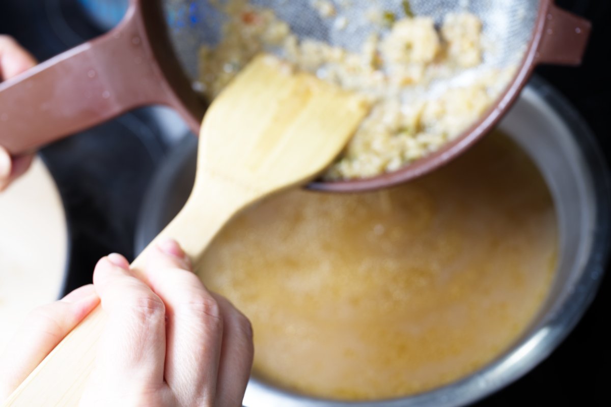 pressing down on solids into the broth