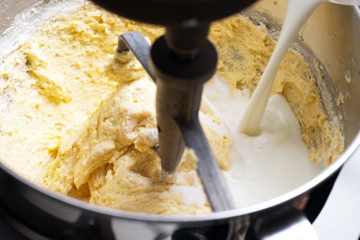 pouring buttermilk into lemon cake batter