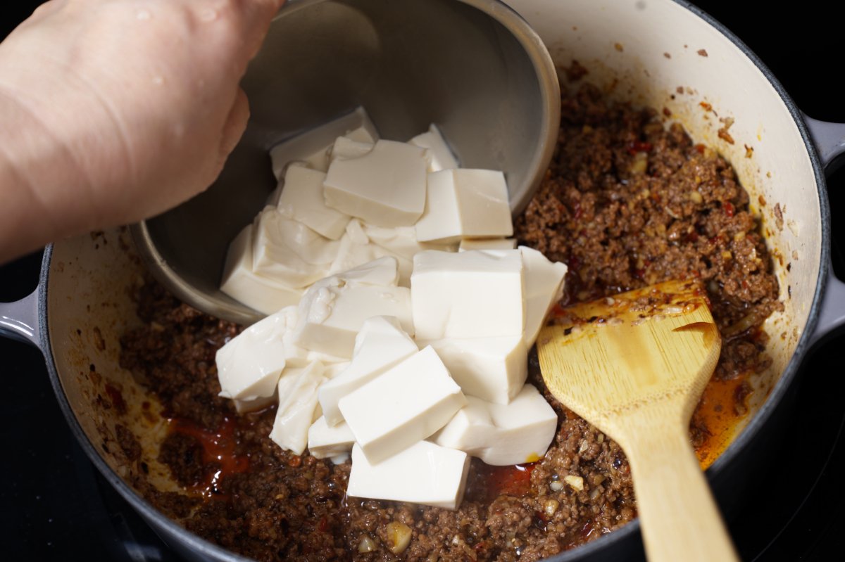 adding the tofu to the mapo