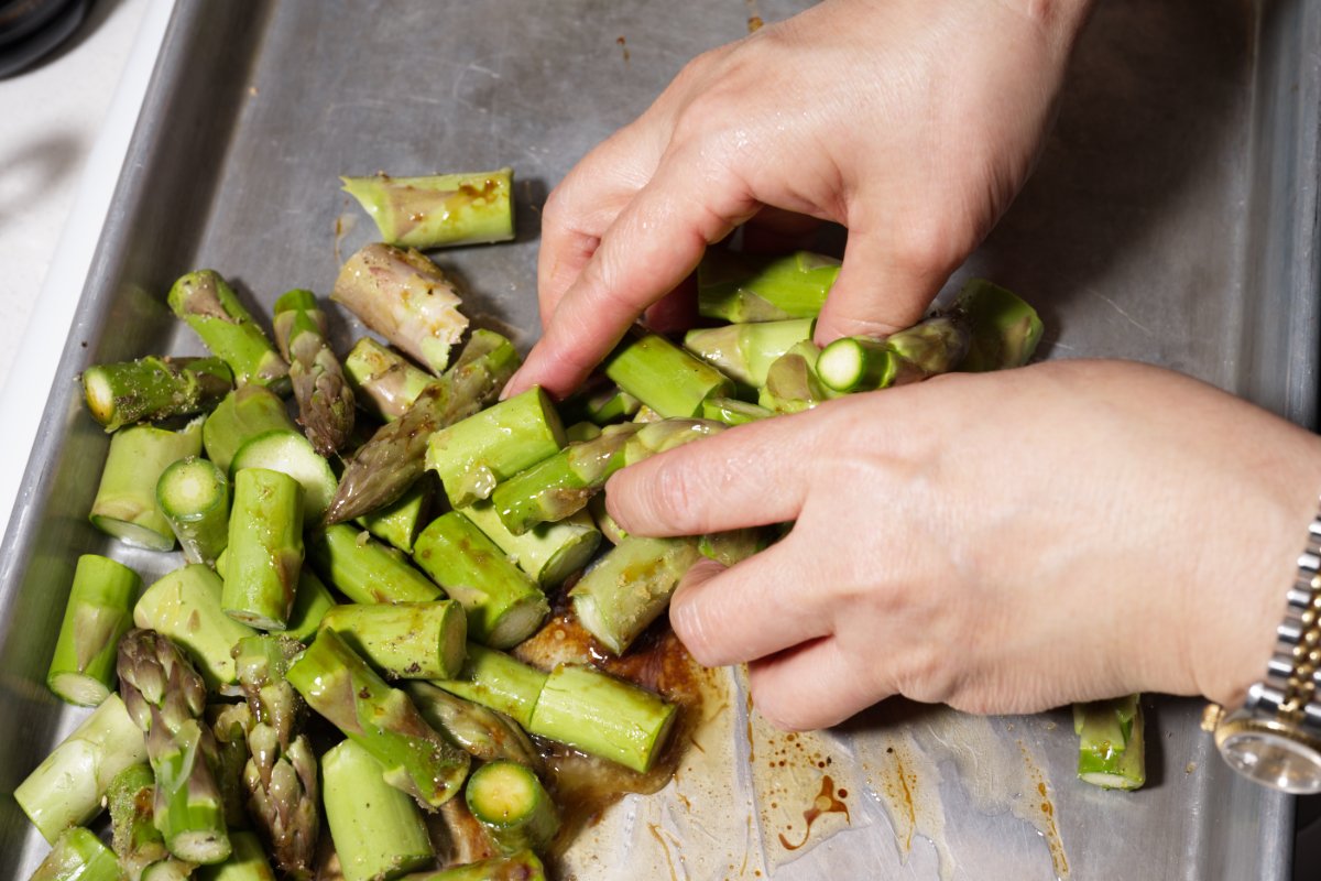 tossing asparagus with hands to mix