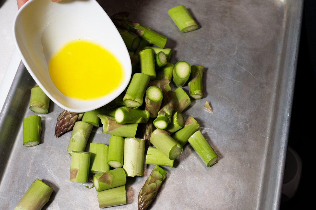 pouring melted butter over asparagus
