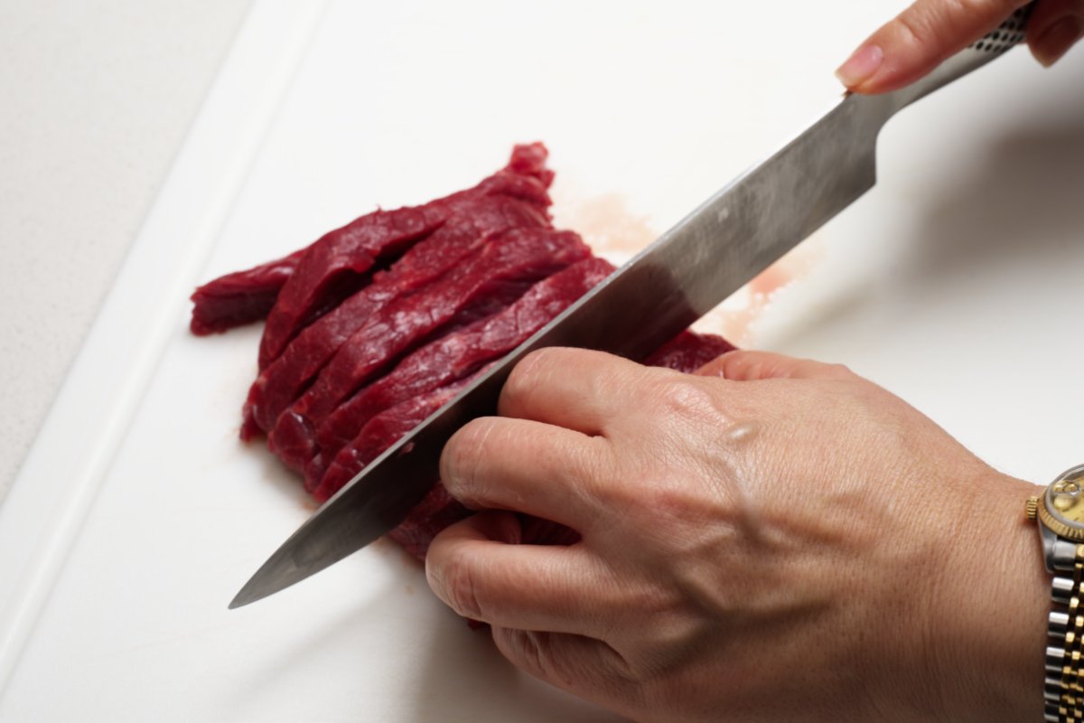 cutting the beef into strips caramelized beef fried rice