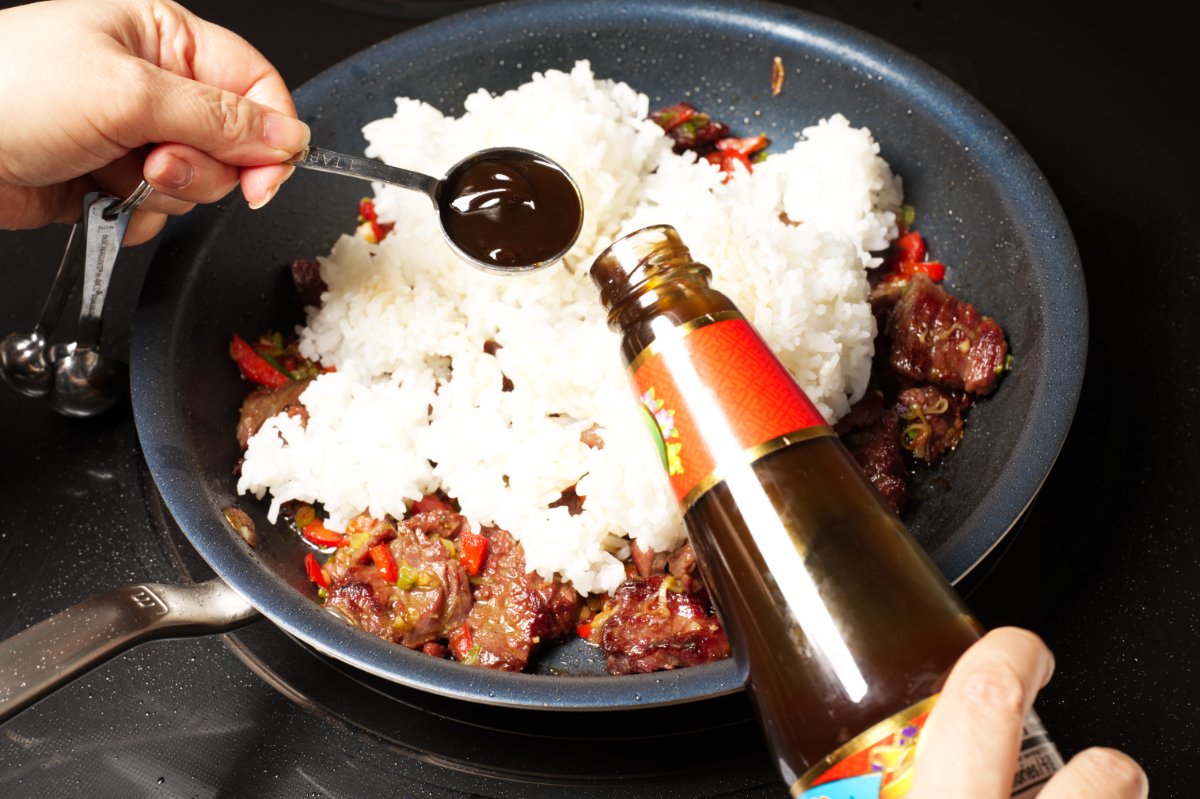 adding sauces to beef fried rice