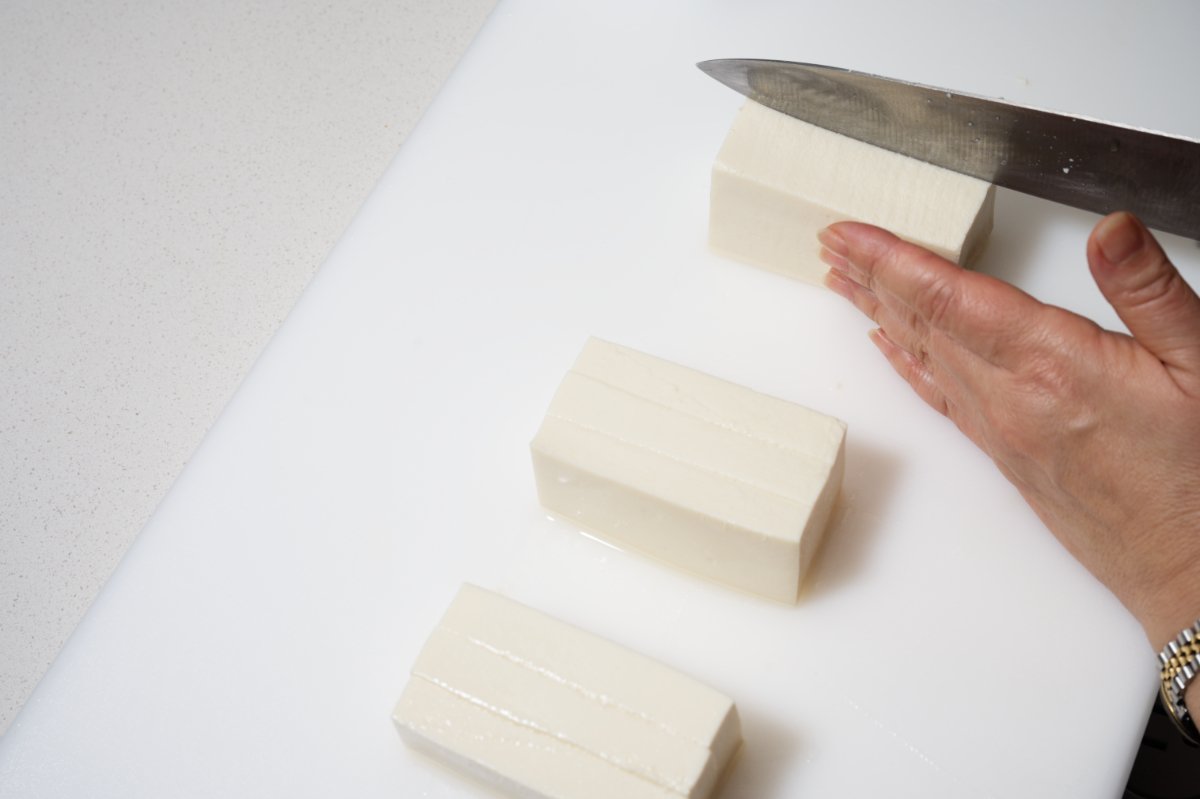 slicing tofu into smaller pieces for terrine