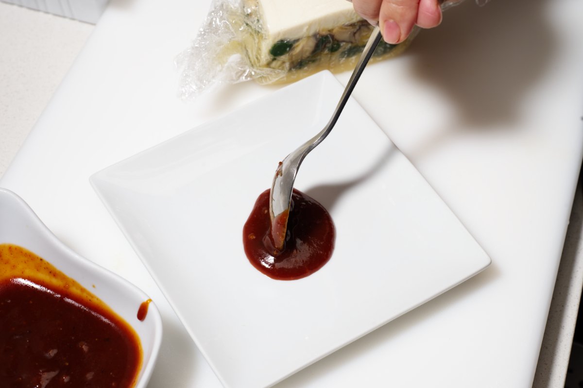 adding sauce to serving plates for chilled tofu terrine