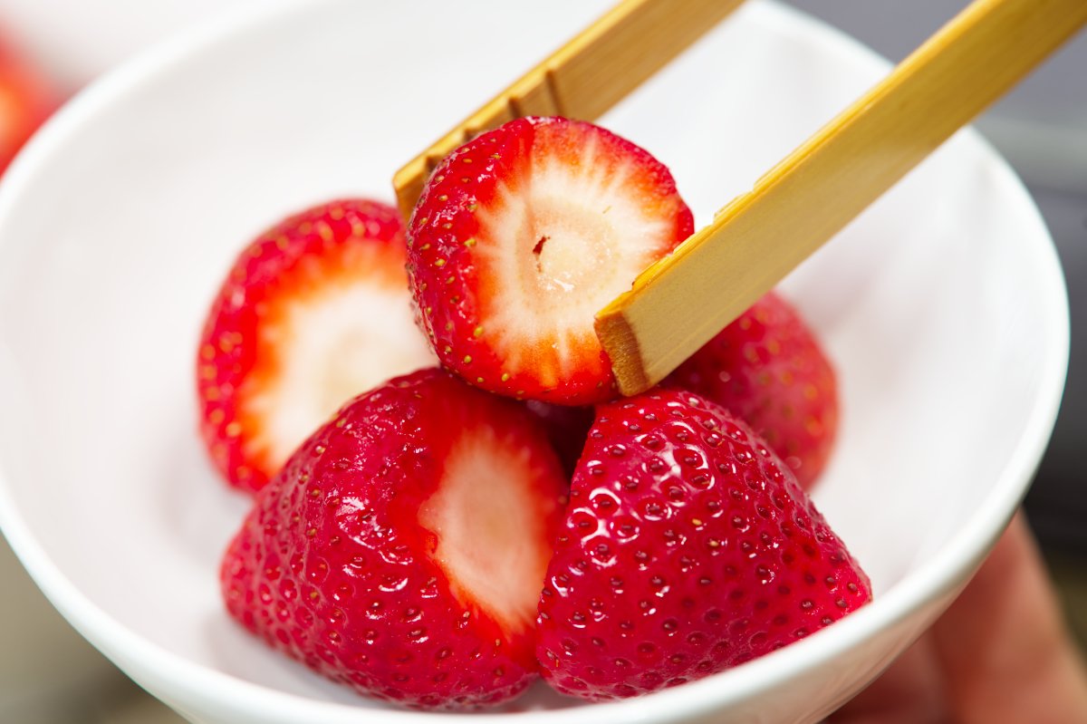 putting strawberries into bowls for strawberries and milk