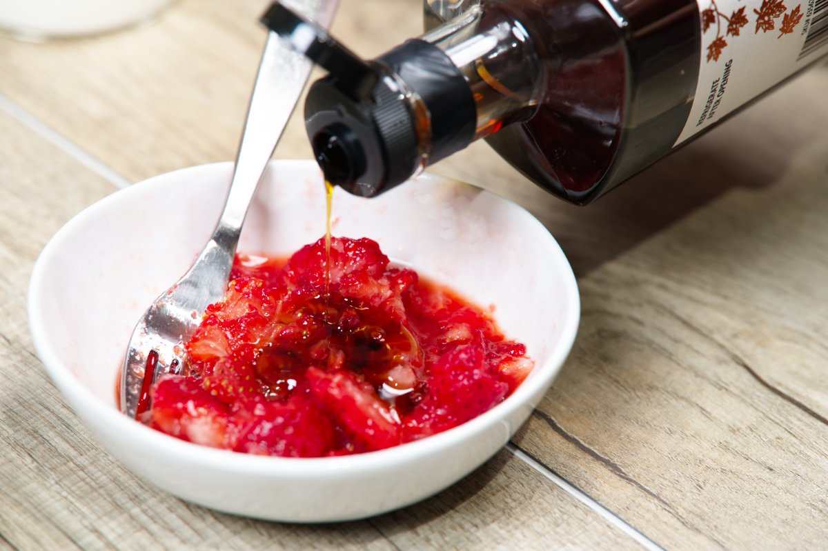 adding syrup to the mashed strawberries