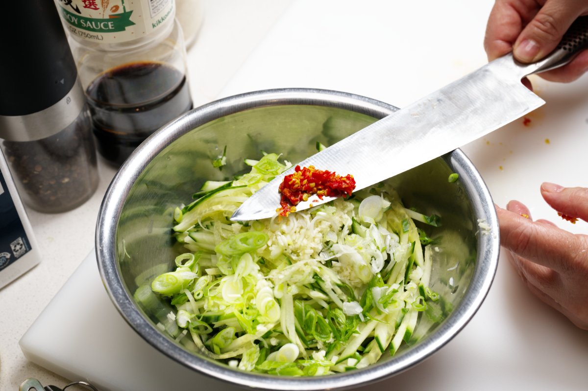 adding chilis to cucumbers