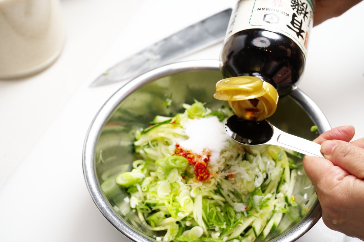 adding soy sauce to chilled watermelon cucumber soup