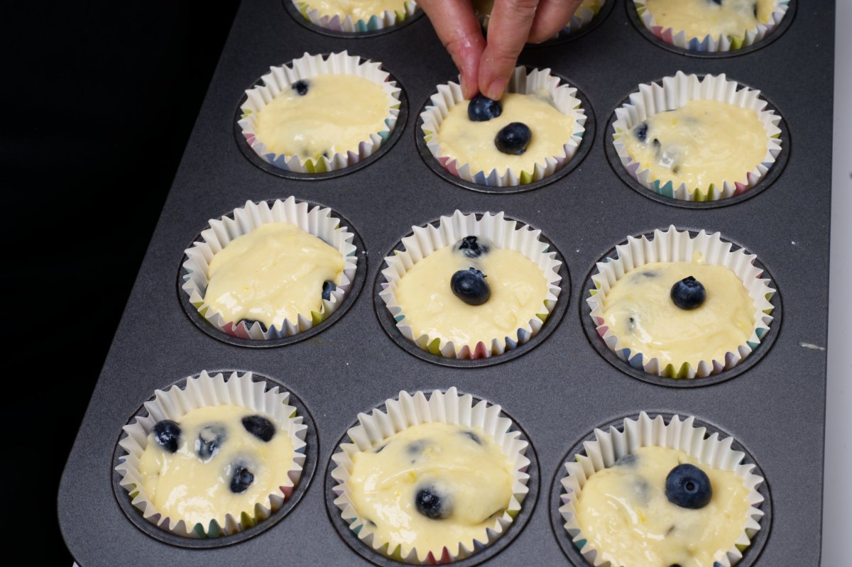 adding berries to top of muffins