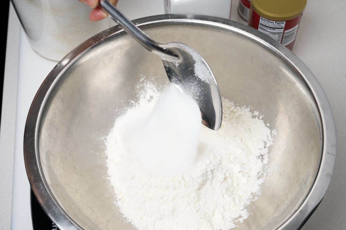 putting flour in bowl blueberry muffins