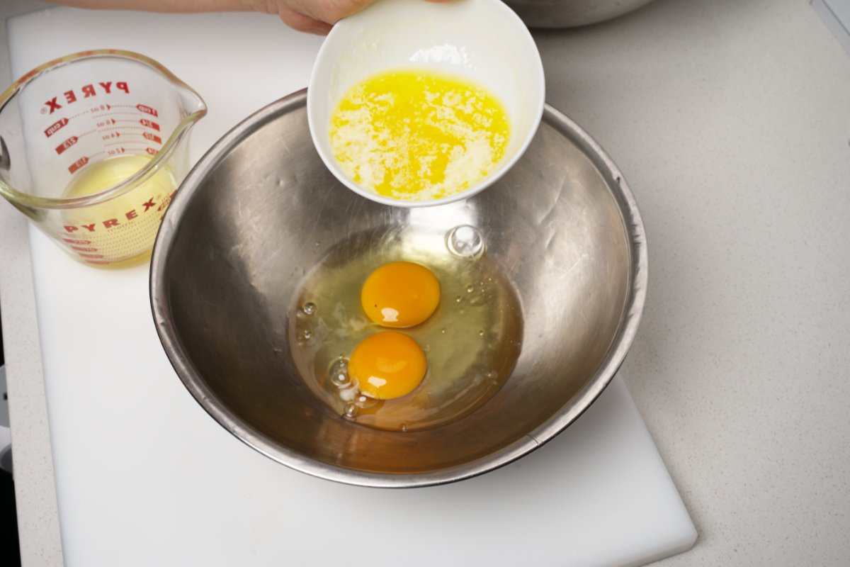 adding melted butter to eggs