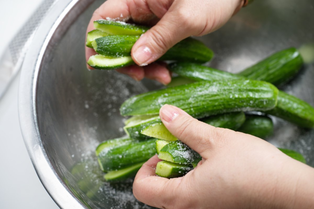 rubbing the salt into the cucumbers
