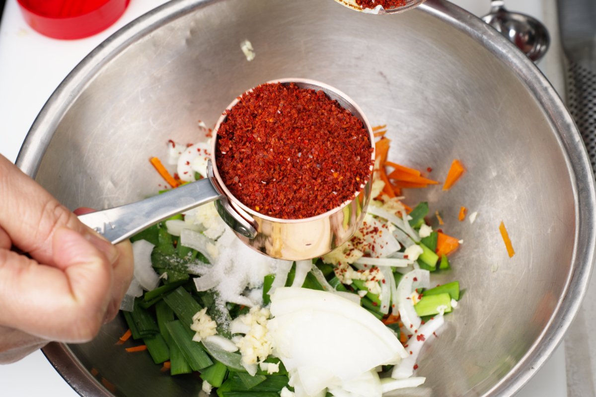 adding gochugaru to stuffed cucumber kimchi