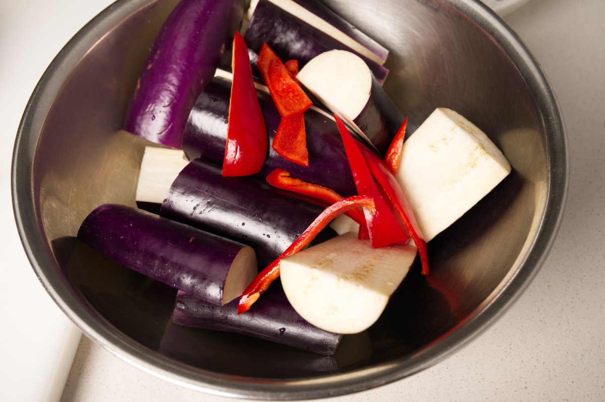 putting eggplant and chili in bowl