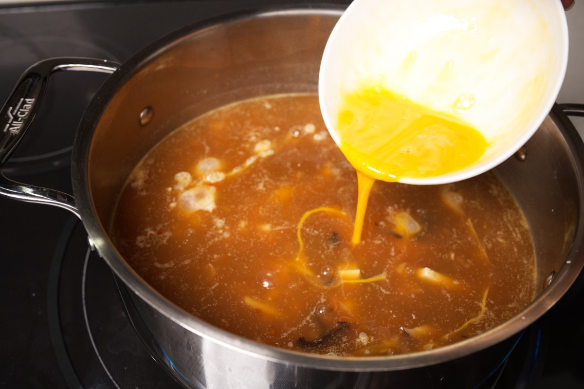 pouring in eggs to hot and sour soup