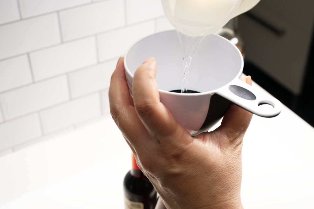 using funnel to pour in vodka for homemade vanilla extract