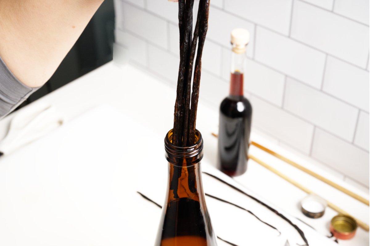 adding beans to bottle for homemade vanilla extract