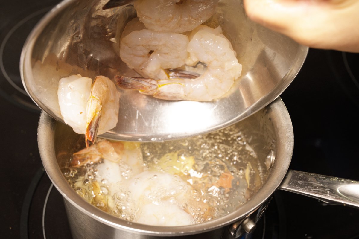 adding shrimp to boiling poaching water