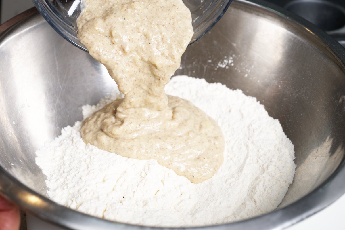 adding wet ingredients to the dry healthy breakfast muffins