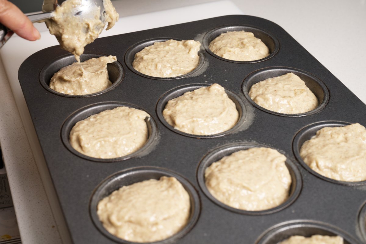 filling the muffin tin for healthy breakfast muffins