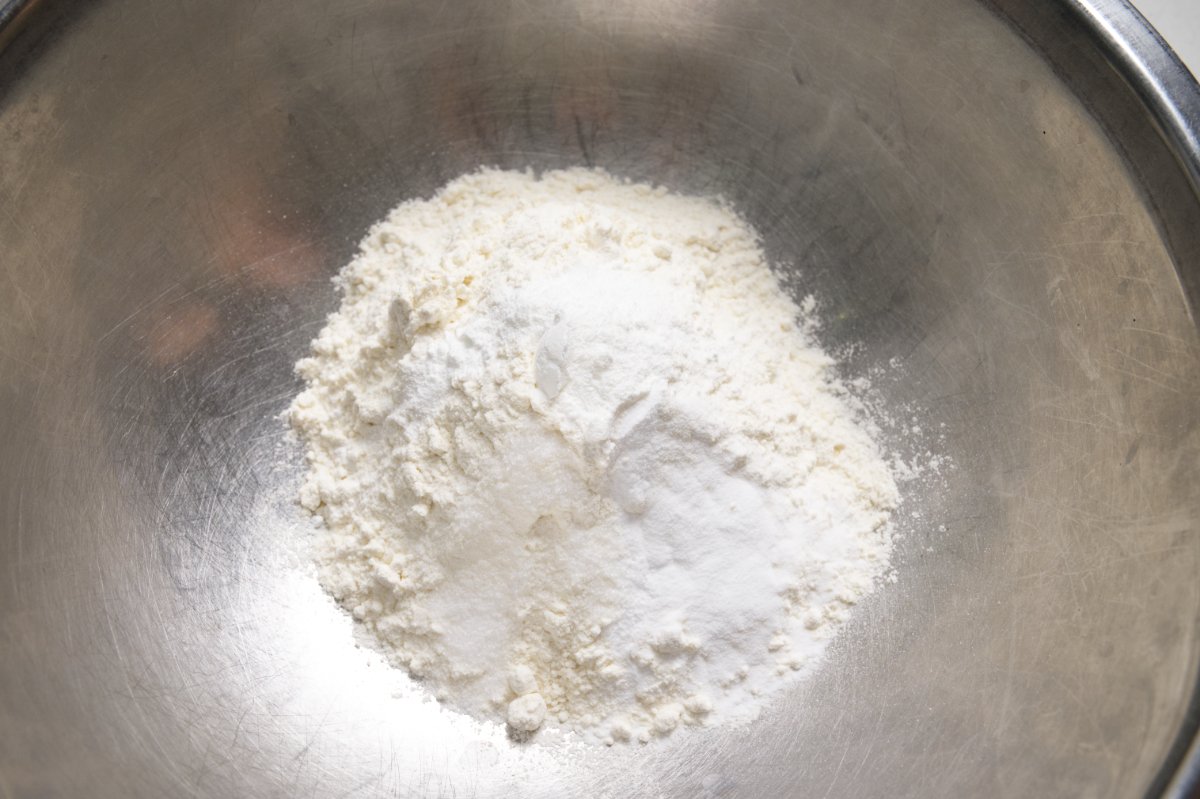 adding flour to mixing bowl for healthy breakfast muffins