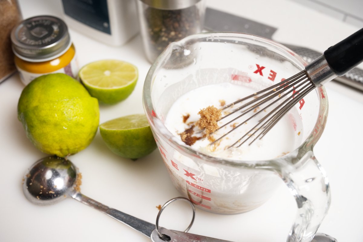 whisking together sauce ingredients for green papaya slaw