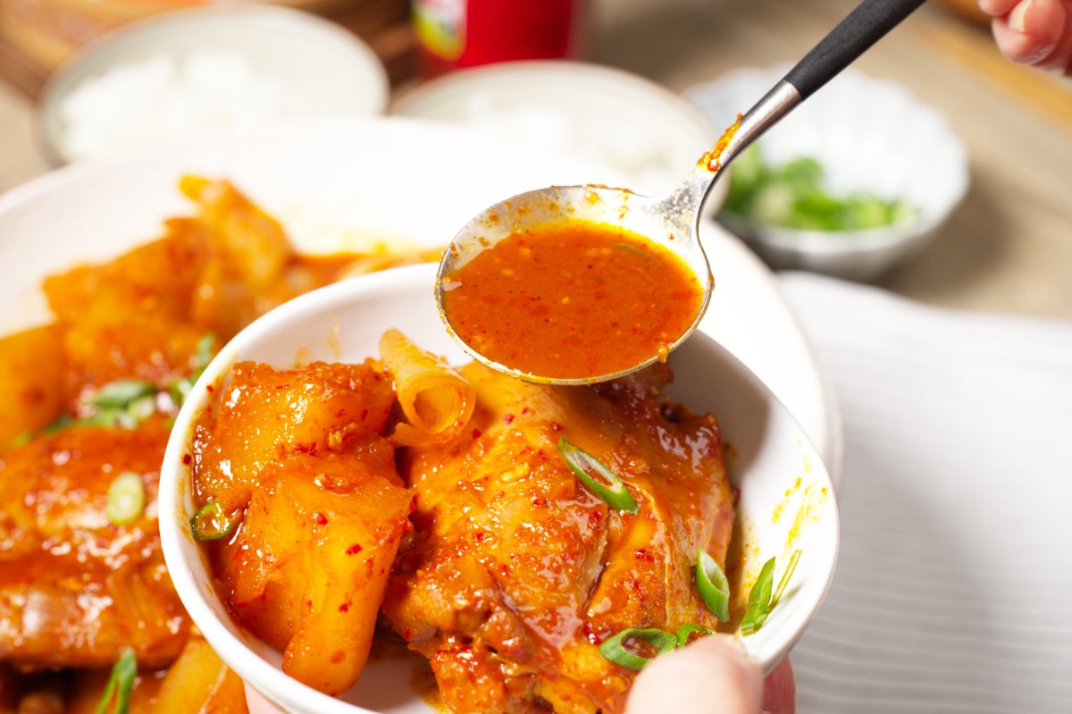 pouring sauce over chicken